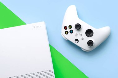 Xbox One S Tüm Dijital Versiyon konsolu ve mavi ve yeşil arkaplan üzerindeki beyaz oyun kablosuz denetleyicisinin üst görünümü