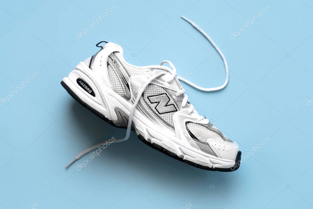 Top view of New Balance sport shoes GR530 over blue background. Illustrative editorial