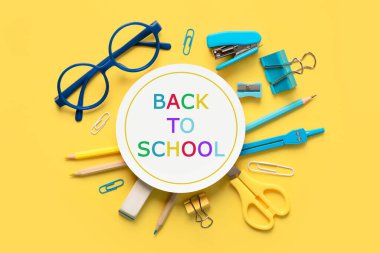 Okul malzemelerinin en üst görüntüsü ve sarı arka planda 