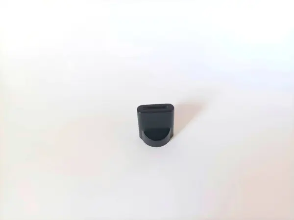 Küçük, siyah plastik hacimli bir düğmenin yakın çekim makro fotoğrafı. Görüntü, bu ortak ses ekipmanı bileşeninin detaylı doku ve tasarımını gösterir.