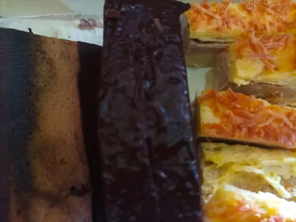Bir kutuda ev yapımı Kek ve Peynirli Kek gösterisi. Bu resim farklı katman ve malzemelerin canlı renklerini ve dokularını gösterir.