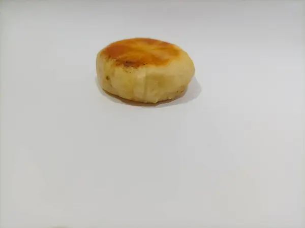 Bakpia beyaz arka planda izole edilmiş. Bu bakpia, buğday unu, yeşil fasulye, peynir ve ananas dolgusundan yapılmış bir Yogyakarta spesiyalidir. Bu bakpia düz yuvarlak ve tatlı bir tadı var..