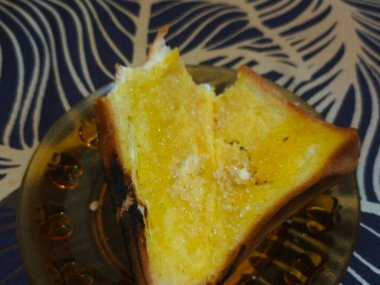 Küçük bir tabakta servis edilen tereyağlı tostun yakın çekimi..