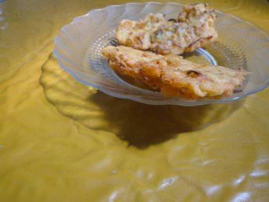 Çıtır Bakwan aperatifi açık kahverengi masa arkaplanlı bir tabakta servis edilir..