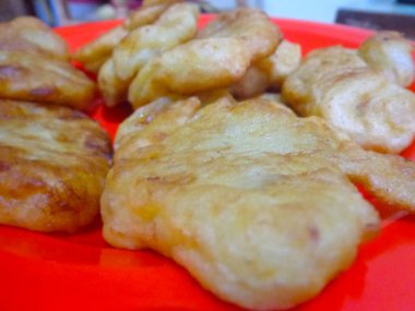 Kırmızı plastik tabakta servis edilen kızarmış muz..