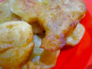 Kırmızı plastik tabakta servis edilen kızarmış muz..