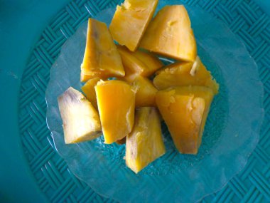 Haşlanmış tatlı patatesler küçük parçalara ayrılır ve beyaz bir tabakta servis edilir..