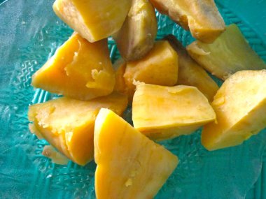 Haşlanmış tatlı patatesler küçük parçalara ayrılır ve beyaz bir tabakta servis edilir..