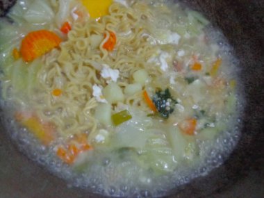 Sebze ve yumurtalarla birlikte erişte pişirme.