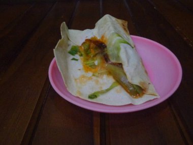 Kebaplar, Endonezya baharat ve sosu ekleyerek modifiye edilir ve plastik tabaklar ve ahşap arka plan kullanılarak servis edilir..