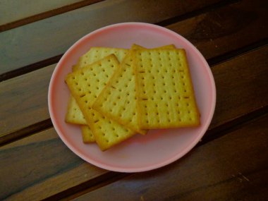 Küçük bir tabak ve ahşap arka planda lezzetli peynirli bisküviler..