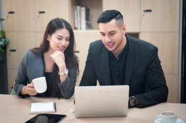 İki iş adamı ofislerinde dizüstü bilgisayarla tartışıyor..