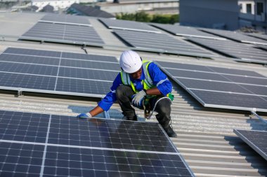Teknoloji güneş pili, mühendis fabrikanın çatısındaki güneş pilini kontrol ediyor. teknisyen güneş panellerinin bakımını kontrol ediyor