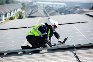 Teknoloji güneş pili, mühendislik servisi fabrikanın çatısındaki güneş pillerini kontrol ediyor. Teknisyenler güneş panellerinin bakımını kontrol ediyor, mühendislik ekibi çalışıyor. 