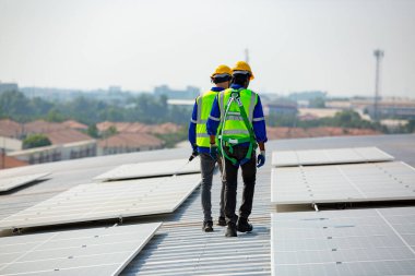 Teknoloji güneş pili, mühendislik servisi fabrikanın çatısında güneş pili kurulumunu kontrol ediyor. Güneş panellerinin bakımını kontrol eden teknisyenler, mühendislik ekibi güneş enerjisi santralinde kontrol ve bakım üzerinde çalışıyor. 