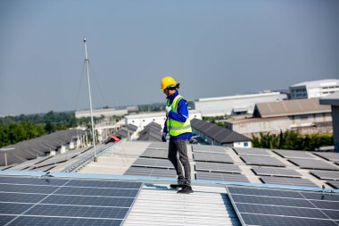 Teknoloji güneş pili, mühendislik servisi fabrikanın çatısında güneş pili kurulumunu kontrol ediyor. teknisyen güneş panellerinin bakımını kontrol ediyor 