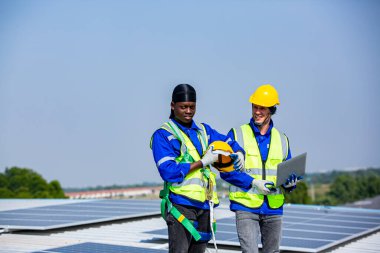 Teknoloji güneş pili, mühendislik servisi fabrikanın çatısındaki güneş pillerini kontrol ediyor. Teknisyenler güneş panellerinin bakımını kontrol ediyor, mühendislik ekibi çalışıyor. 