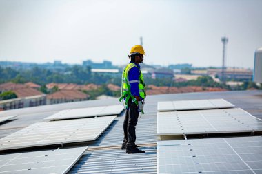 Teknoloji güneş pili, mühendis fabrikanın çatısındaki güneş pilini kontrol ediyor. teknisyen güneş panellerinin bakımını kontrol ediyor