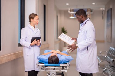 Hastane koridorunda sedyeyle koşan doktor.