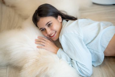 Evcil köpeği evde olan genç bir kadın.