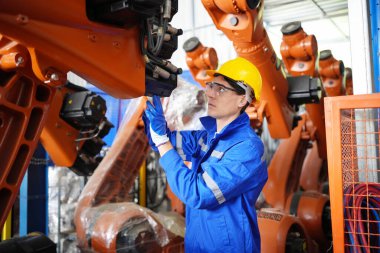 Kontrol mühendisi ve kaynak robotik otomatik silah Makinası akıllı Fabrika otomotiv endüstriyel sistem yazılımı izleme ile kontrol edin. Dijital üretim işlemi. Sanayi 4.0