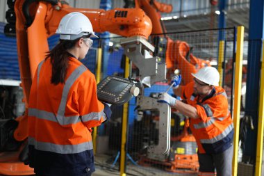 Kontrol mühendisi ve kaynak robotik otomatik silah Makinası akıllı Fabrika otomotiv endüstriyel sistem yazılımı izleme ile kontrol edin. Dijital üretim işlemi. Sanayi 4.0