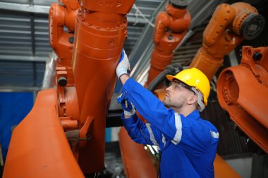 Kontrol mühendisi ve kaynak robotik otomatik silah Makinası akıllı Fabrika otomotiv endüstriyel sistem yazılımı izleme ile kontrol edin. Dijital üretim işlemi. Sanayi 4.0