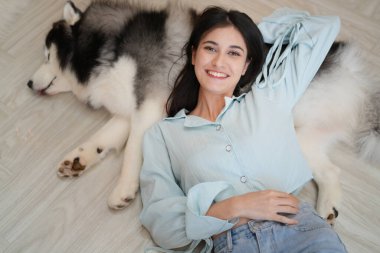 Neşeli kadın evinde köpeğiyle oynuyor..