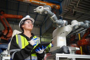 Kontrol mühendisi ve kaynak robotik otomatik silah Makinası akıllı Fabrika otomotiv endüstriyel sistem yazılımı izleme ile kontrol edin. Dijital üretim işlemi. Sanayi 4.0