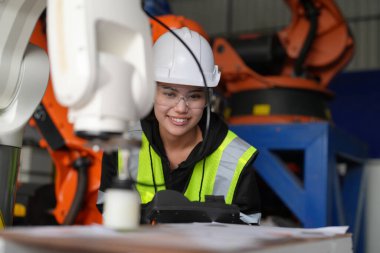 Kontrol mühendisi ve kaynak robotik otomatik silah Makinası akıllı Fabrika otomotiv endüstriyel sistem yazılımı izleme ile kontrol edin. Dijital üretim işlemi. Sanayi 4.0