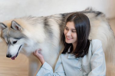 Neşeli kadın evinde köpeğiyle oynuyor..