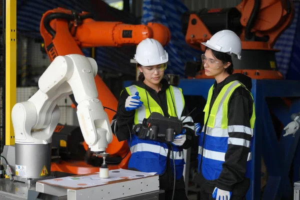 Kontrol mühendisi ve kaynak robotik otomatik silah Makinası akıllı Fabrika otomotiv endüstriyel sistem yazılımı izleme ile kontrol edin. Dijital üretim işlemi. Sanayi 4.0