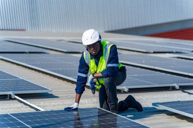 Teknoloji güneş pili, mühendis fabrikanın çatısındaki güneş pilini kontrol ediyor. teknisyen güneş panellerinin bakımını kontrol ediyor