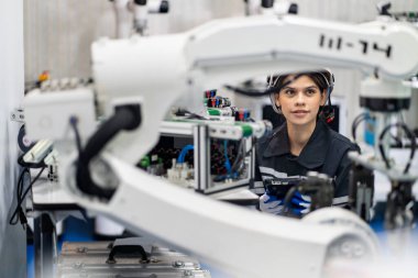 Mühendis, akıllı fabrika otomotiv endüstrisinde kaynak yapan otomatik silah makinesini kontrol ediyor ve kontrol ediyor. Dijital üretim operasyonu. Sektör 4.0