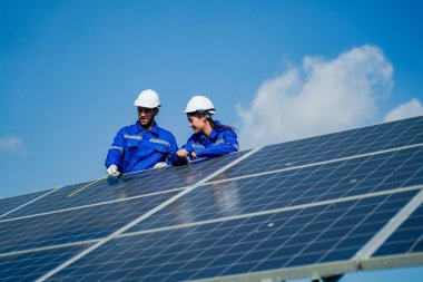 Teknoloji güneş pili, mühendislik servisi fabrikanın çatısında güneş pili kurulumunu kontrol ediyor. teknisyen güneş panellerinin bakımını kontrol ediyor