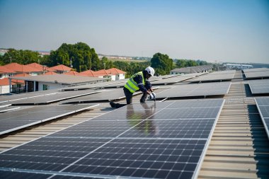 Teknoloji güneş pili, mühendis fabrikanın çatısındaki güneş pilini kontrol ediyor. teknisyen güneş panellerinin bakımını kontrol ediyor