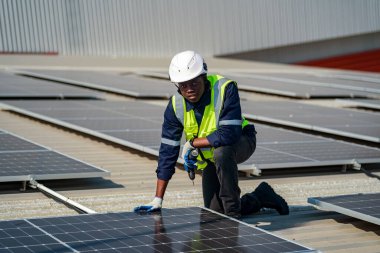 Teknoloji güneş pili, mühendis fabrikanın çatısındaki güneş pilini kontrol ediyor. teknisyen güneş panellerinin bakımını kontrol ediyor