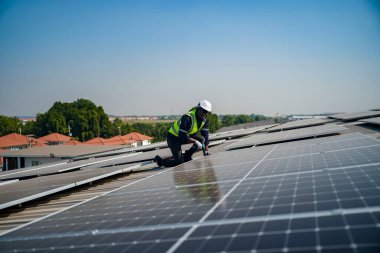 Teknoloji güneş pili, mühendis fabrikanın çatısındaki güneş pilini kontrol ediyor. teknisyen güneş panellerinin bakımını kontrol ediyor