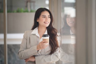 Elinde kahve fincanı olan Asyalı iş kadını 