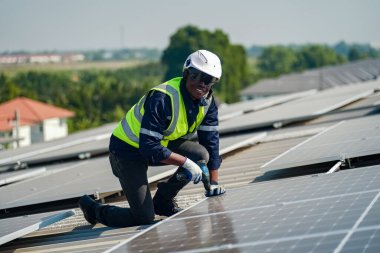 Teknoloji güneş pili, mühendis fabrikanın çatısındaki güneş pilini kontrol ediyor. teknisyen güneş panellerinin bakımını kontrol ediyor