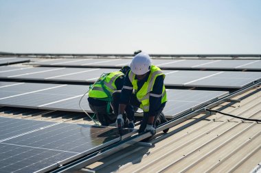Teknoloji güneş pili, mühendislik servisi fabrikanın çatısında güneş pili kurulumunu kontrol ediyor. Güneş panellerinin bakımını kontrol eden teknisyenler, mühendislik ekibi güneş enerjisi santralinde kontrol ve bakım üzerinde çalışıyor. 