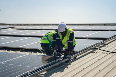 Teknoloji güneş pili, mühendislik servisi fabrikanın çatısında güneş pili kurulumunu kontrol ediyor. Güneş panellerinin bakımını kontrol eden teknisyenler, mühendislik ekibi güneş enerjisi santralinde kontrol ve bakım üzerinde çalışıyor. 