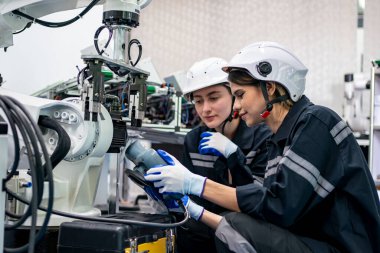 Mühendisler, akıllı fabrika otomotiv endüstrisinde kaynak yapan otomatik silah makinelerini kontrol ediyorlar ve kontrol ediyorlar. Dijital üretim operasyonu. Sektör 4.0