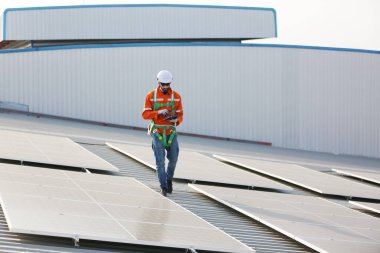 Makinist çatıya güneş panelleri kuruyor. Erkek mühendis çalışıyor. 