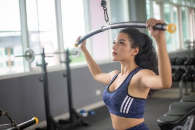 Formda, Afro-Amerikan bir kadının vücut ağırlıklarıyla spor salonunda spor yaparken görüntüsü..