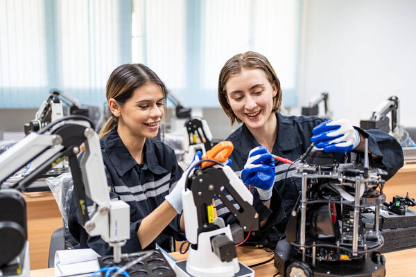 Engineers checking and controling welding robotics automatic arms machine in intelligent factory automotive industrial with monitoring system software. Digital manufacturing operation. Industry 4.0