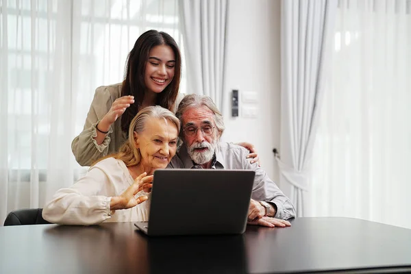 stock image senior couple with daughter using laptop at home