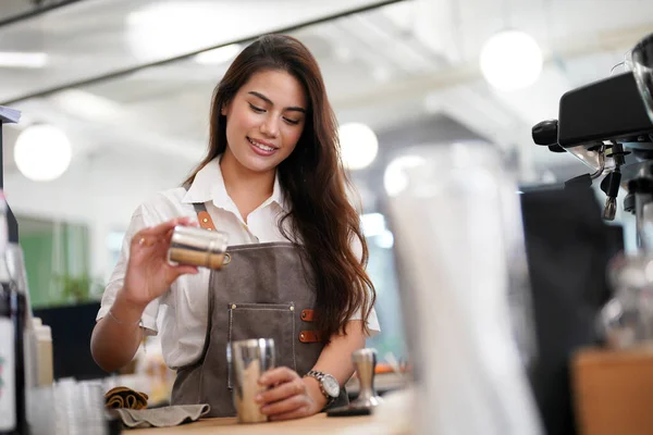 stock image Portrait of happy woman standing in her store. Cheerful waitress waiting for clients at coffee shop. Successful small business owner in casual wearing grey apron