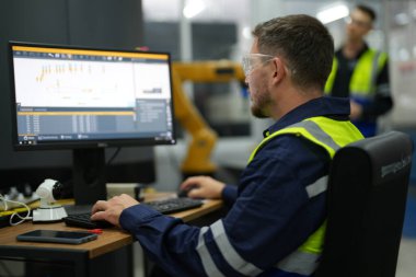 Fabrikada çalışan bir adam, üretim mühendisliği.