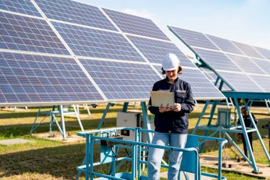 Teknoloji güneş pili, mühendislik servisi fabrikanın çatısında güneş pili kurulumunu kontrol ediyor. teknisyen güneş panellerinin bakımını kontrol ediyor